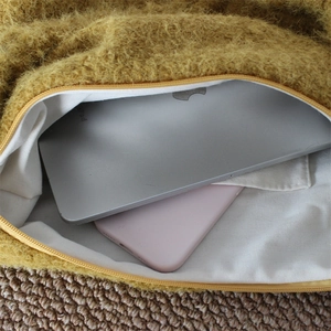 Detail view of large capacity plush tote bag interior holding an iPad and smartphone