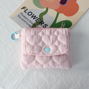 Close-up of pink quilted heart pouch with blue snap pocket and silver zipper details