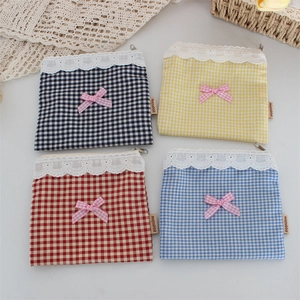 Dettaglio di quattro pochette in tessuto a quadri con pizzo e fiocchi rosa eleganti