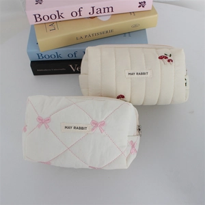 Detailed close-up of quilted cosmetic bags with mushroom and bow embroidery details