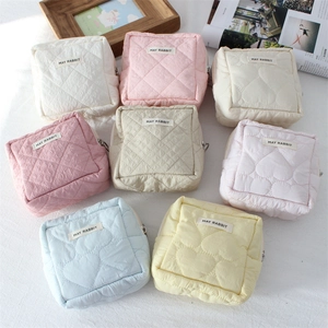 Close-up of colorful quilted fabric makeup bags with metal zippers and May Rabbit labels