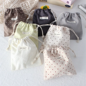 Detailed view of colorful polka dot drawstring bags with a mini fabric brand label