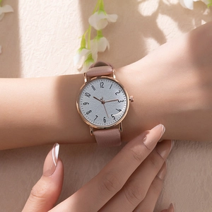 Detail of a ladies' quartz watch with pink leather strap and marble textured dial