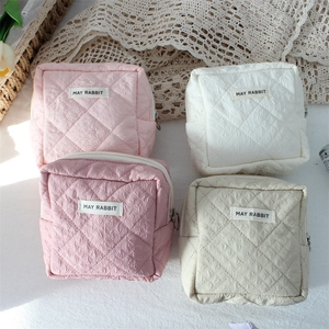 Quilted cosmetic bags in pink and beige colors with a vintage floral background