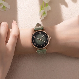 Detail of green leaf pattern gradient dial with rose gold case on leather strap watch