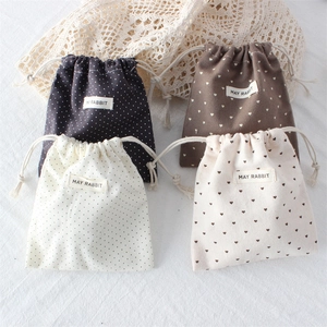 Polka dot and heart patterned cotton drawstring pouches shown in a flat lay arrangement