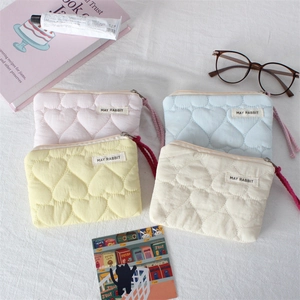 Detailed macro view of quilted heart pattern and woven pull cord on mini cosmetic bags
