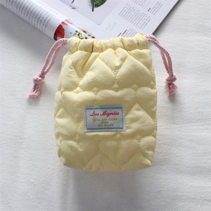 Detail of quilted heart pattern on yellow camera pouch with pink drawstring