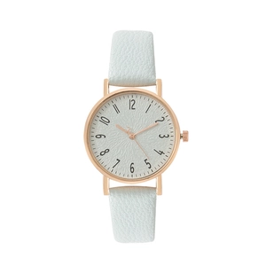 Detailed macro view of mint green leather strap and rose gold quartz watch dial