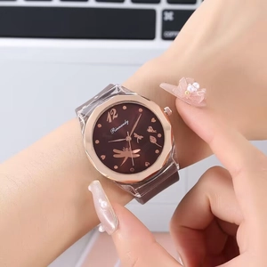 Detailed close-up of rose gold octagonal watch face with floral and dragonfly pattern