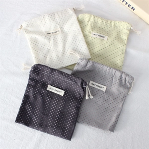 Close-up of four-piece polka dot drawstring storage bags in neutral color fabric tones