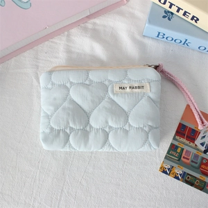 Close-up of light blue heart-quilted coin purse with MAY RABBIT label and pink wristlet