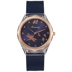 Close-up of rose gold watch bezel with dragonfly and butterfly patterns on blue dial