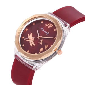 Detail view of burgundy silicone strap watch with dragonfly dial and rose gold bezel