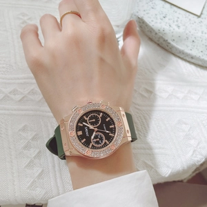 Macro shot of fashion watch with diamond bezel, black dial and dark green silicone strap