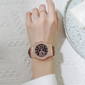 Close-up of a women quartz watch with crystal bezel and dark brown silicone strap