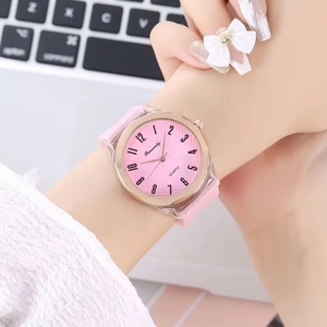 Macro shot of a pink quartz watch with a clear octagonal case on a person's wrist