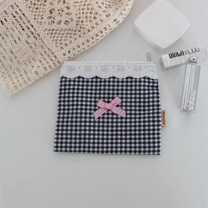 Dettaglio pochette a quadretti con pizzo bianco e fiocco rosa su fondo marmo