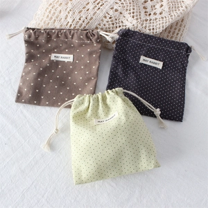Detailed view of three mini polka dot drawstring pouches with MAY RABBIT woven labels