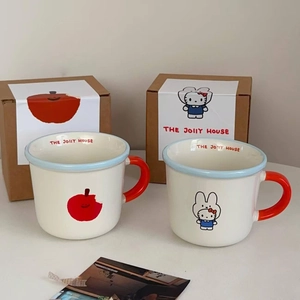 Detail of ceramic mugs with red apple and rabbit prints in elegant gift packaging