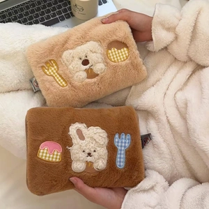 Detail of soft plush hot water bottle cover with cute cartoon bunny and bear embroidery
