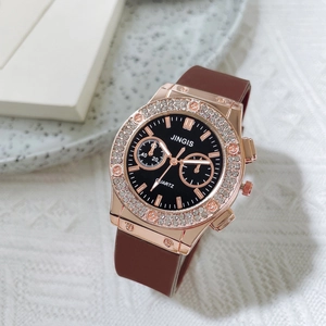 Macro view of rose gold rhinestone bezel and brown silicone strap on quartz watch