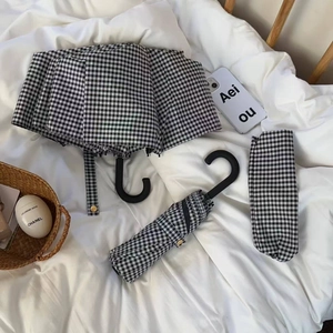 Foldable black and white checkered sun umbrella with vintage J-shaped hook handle