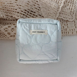 Detail of light blue quilted heart pattern pouch with zipper and May Rabbit brand label