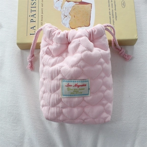 Detail view of pink heart-quilted drawstring storage bag with soft protective padding