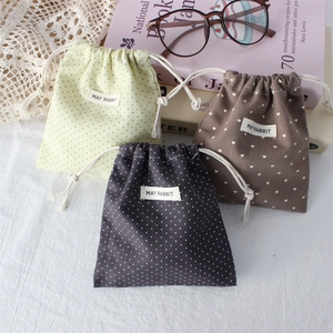 Detailed view of polka dot and heart pattern cotton drawstring storage pouches on table