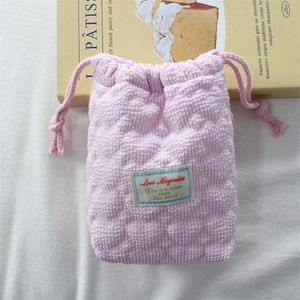 Detailed view of pink checkered quilted cotton drawstring pouch with heart patterns