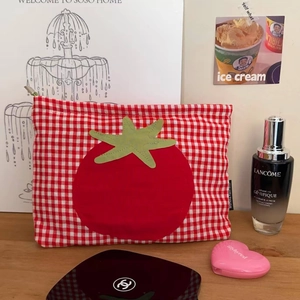 Detail der rot-weiß karierten Kosmetiktasche mit Tomaten-Patch und Reißverschluss im Alltag