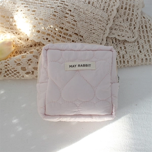 Detailed view of pink heart quilted fabric with May Rabbit label on small makeup bag