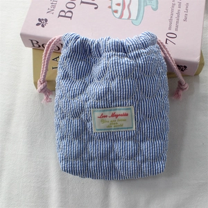 Close-up of quilted heart camera pouch with blue stripes and drawstring closure