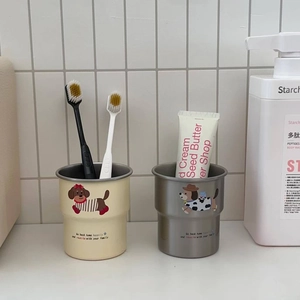 Close-up of cute cartoon dog illustration on cream and grey wash cups in bathroom