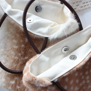 Detail of deer print plush bag with canvas lining and magnetic snap closure