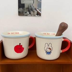Cute ceramic mugs with cartoon apple and cat illustrations and red handles for coffee