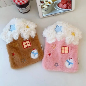 Detail of plush house-shaped hot water bottle cover with snowman embroidery and soft faux snow