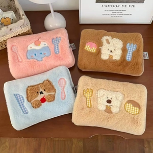 Detail of four colorful plush electric hot water bottles with cute animal embroidery