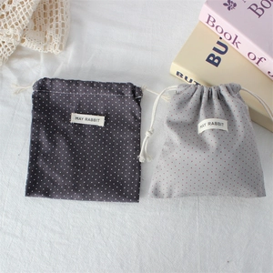 Detail of polka dot cotton drawstring pouches showing fabric texture and woven labels