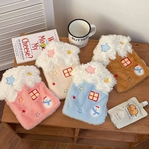 Close-up of four house-shaped hot water bottle covers with snow plush and snowman embroidery