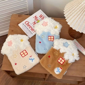 Three plush star house water bags in white, blue and brown on a cozy wooden bedside table