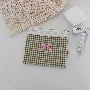 Dettaglio della borsa a quadretti verdi con fiocco rosa e bordo in pizzo delicato