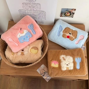 Close-up of cute plush makeup bags featuring soft faux rabbit fur and towel embroidery