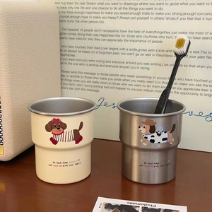 Close-up of stackable stainless steel dog cups in beige and grey with cute illustrations