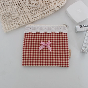 Dettaglio della pochette a quadretti rossi con fiocco rosa e pizzo bianco elegante