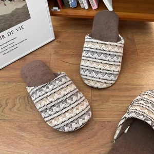 Japanische Leinenhausschuhe mit Bohemian-Strickmuster auf warmem Holzboden