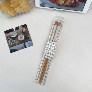 Dettaglio di bacchette in bambù con testa di orsetto 3D in una confezione regalo chic