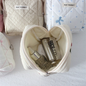 Close-up of quilted cosmetic bag interior showing spacious storage for makeup and skincare