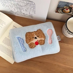 Close-up of a light blue plush electric hot water bag featuring cute dog embroidery